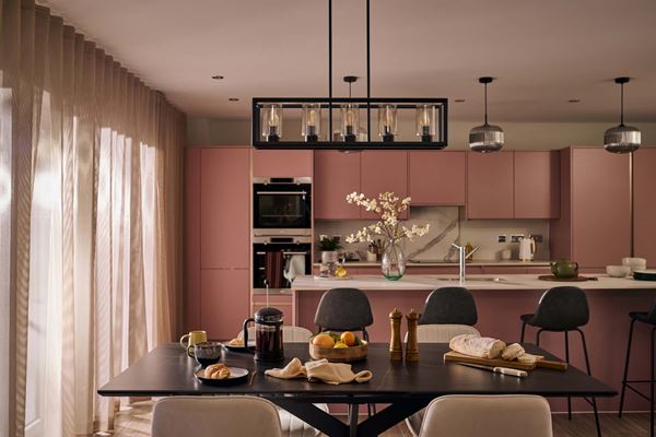 Modern dusky pink kitchen in new build house with black accent furniture.