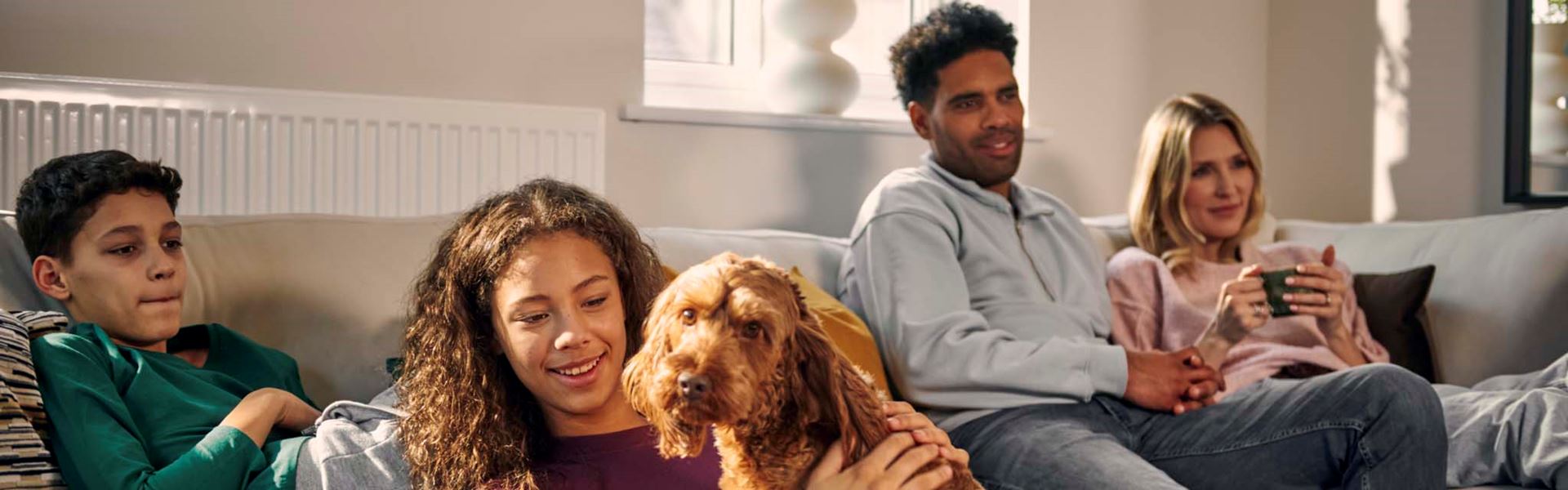 Family with cockerpoo dog in living room of Charles Church new home