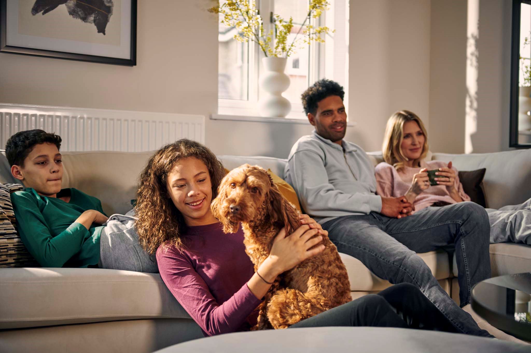 Family with cockerpoo dog in living room of Charles Church new home