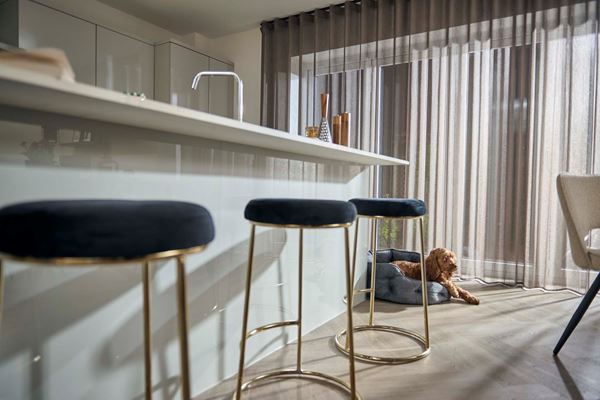 Kitchen island in a Charles Church new home with cockerpoo dog sat next to it.
