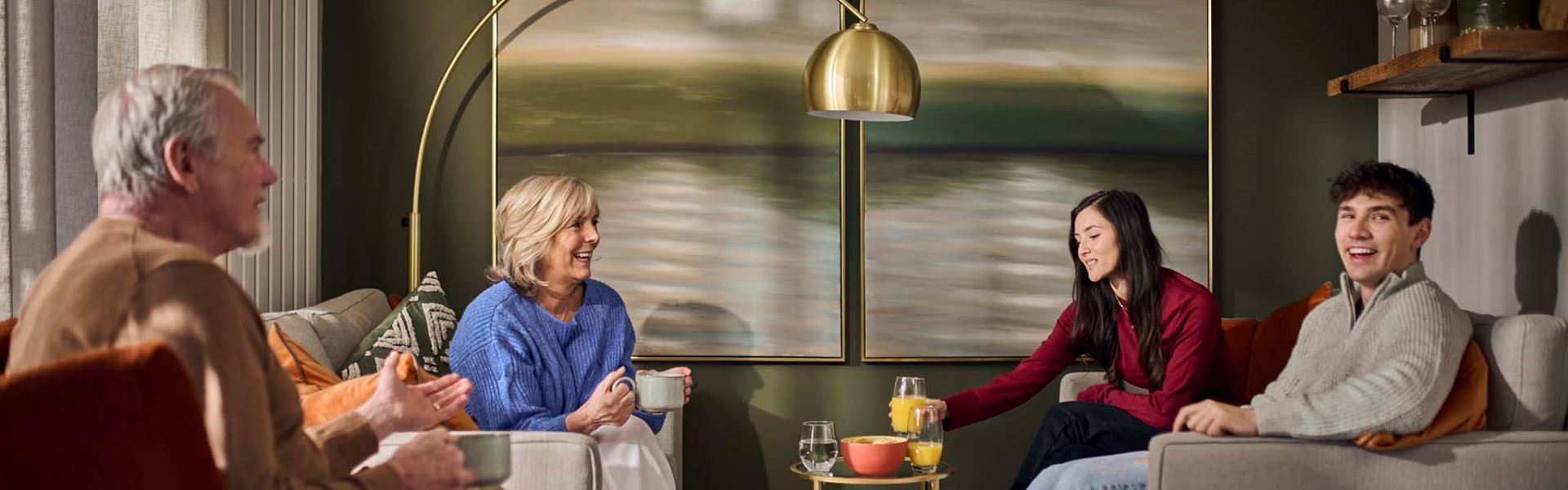 A young couple and parents socialising in a modern living room