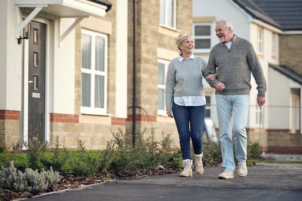 elderly couple walking down the street in a Charles Church development