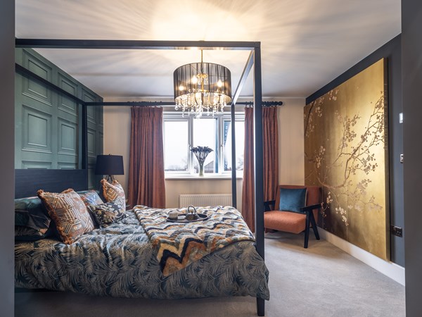 Double bedroom with four poster bed and gold wallpaper
