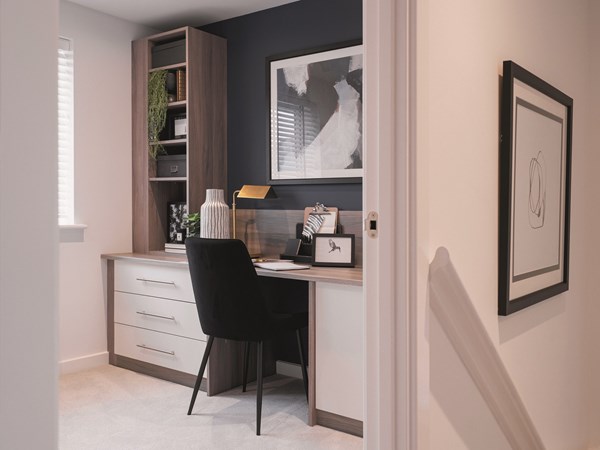 home office with black office chair inbuild storage and gold lamp with artwork