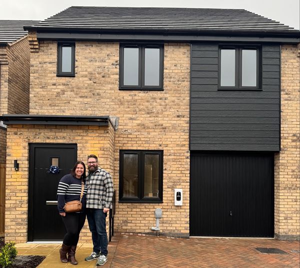 A man and a woman standing outside their new Charles Church home. 