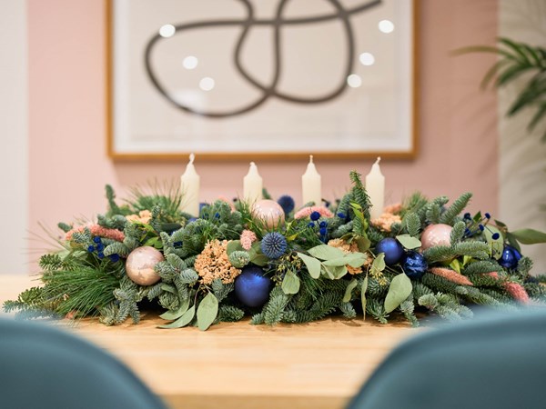 Blue Christmas decorations with candles in a Christmas centrepiece for the dining table